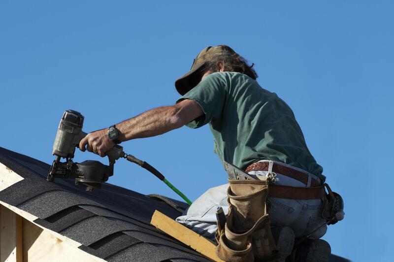 construction worker drilling roof