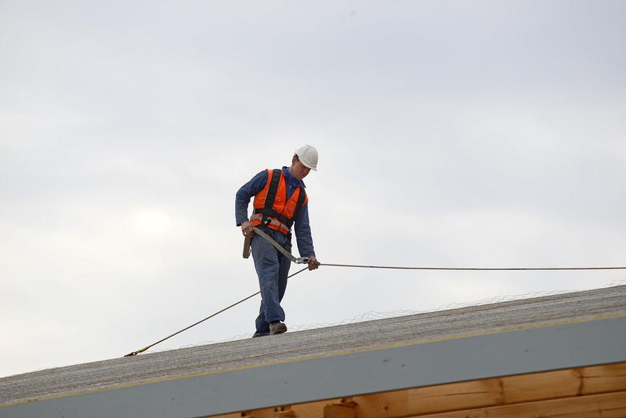 construction worker inspecting roof